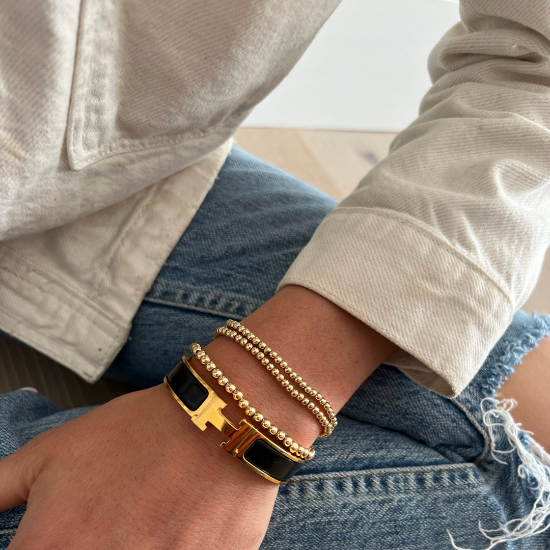 3mm and 4mm gold ball bracelet on wrist with hermes bracelet