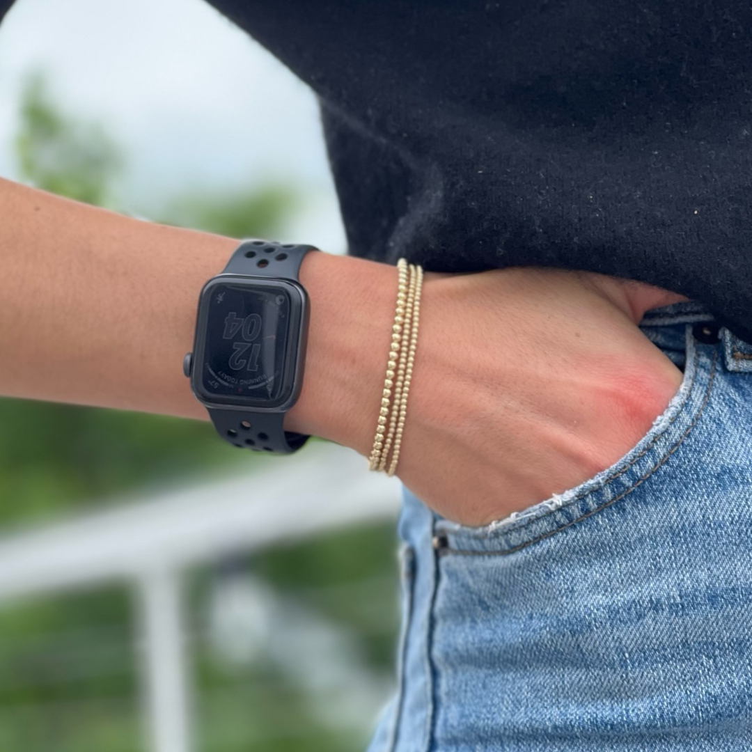 gold ball bracelet stack next to apple watch on wrist