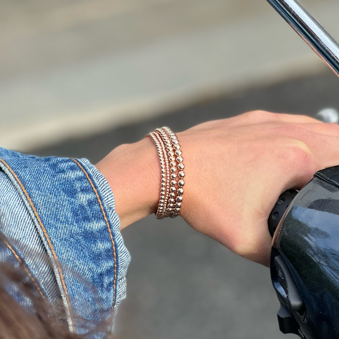 stack of rose gold ball bracelets on wrist