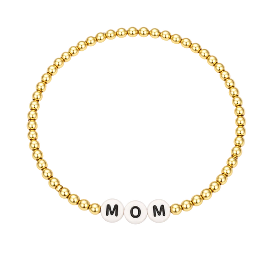 Gold beaded bracelet with a small white bead displaying 'MOM' on a white background