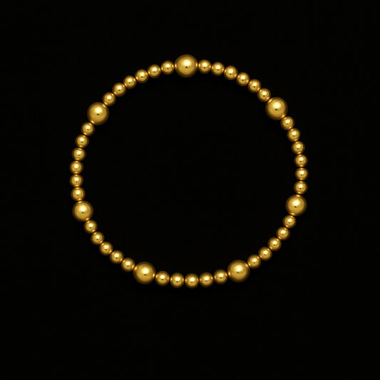 Gold beaded bracelet on a black background