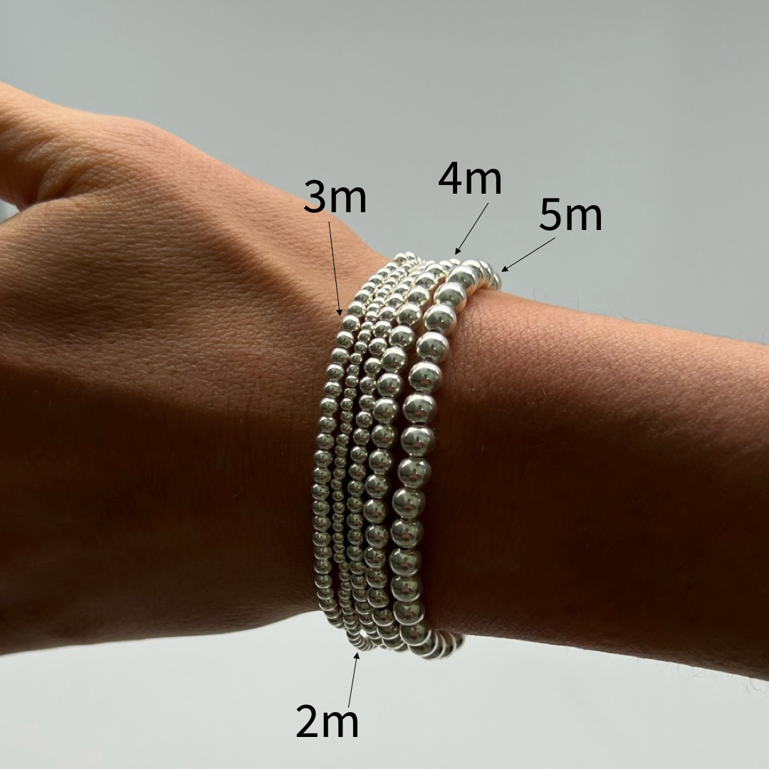 comparison stack of silver ball bracelets on wrist