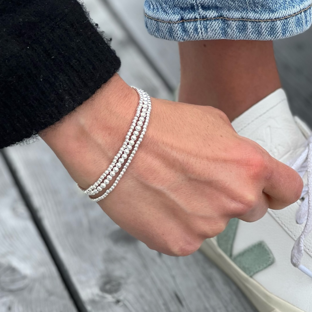 Silver bracelets stack on wrist